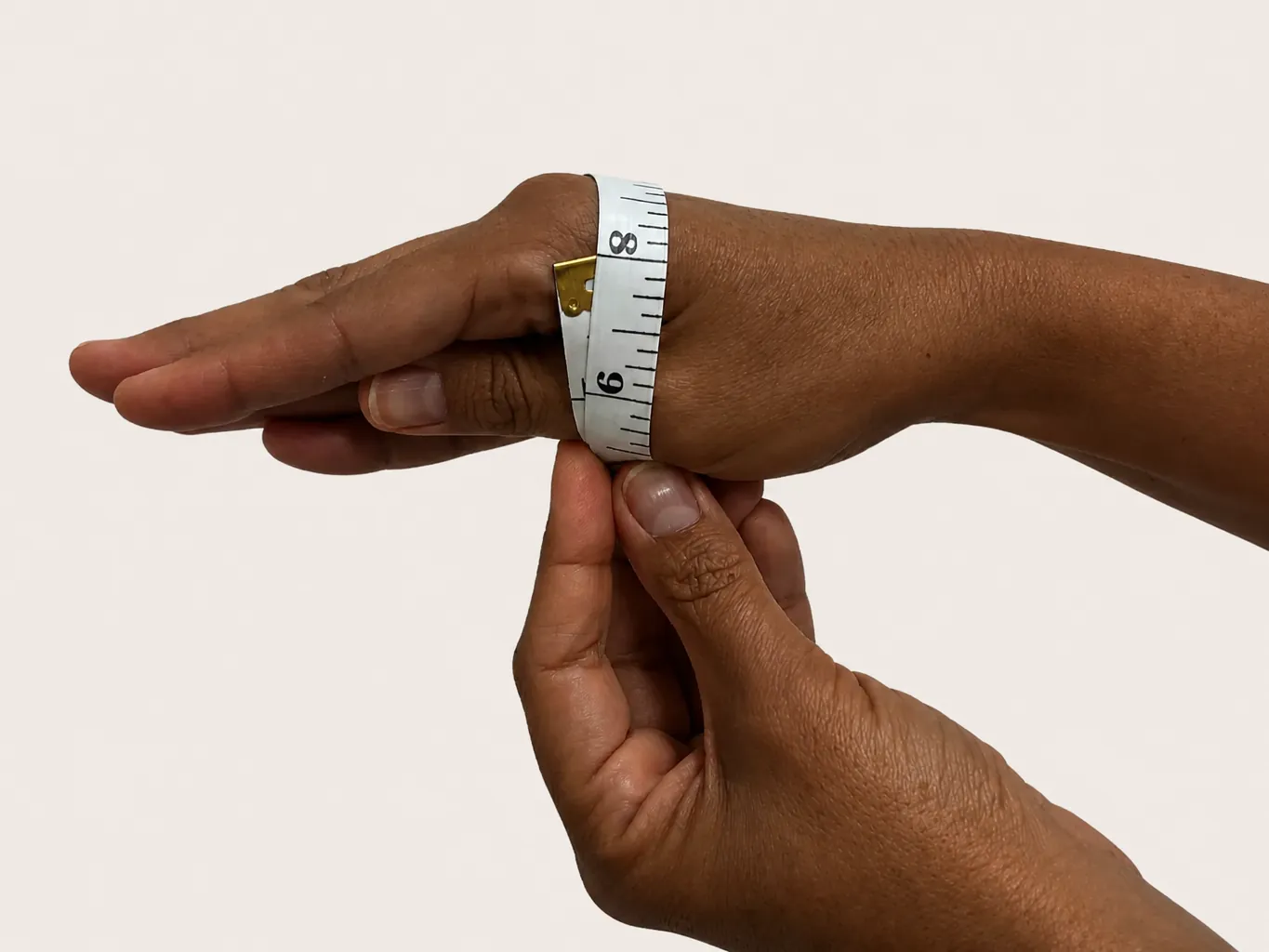 Hands measured with a tape across the knuckles